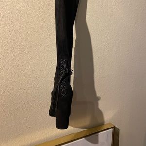A pair of black wide calf suede thigh high boots.